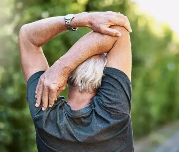adult stretching behing back